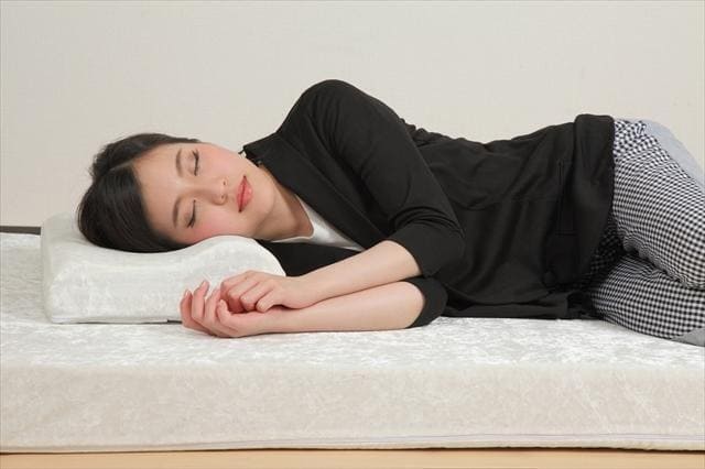 横向きでモットン枕を使って眠る女性の使用イメージ