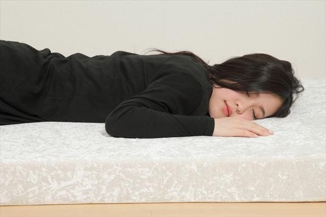 モットン マットレスで女性がうつぶせで寝ている画像